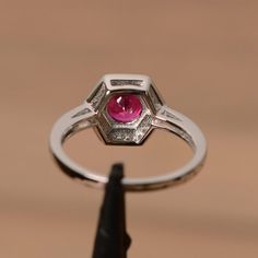 It is a lab ruby ring. The main stone is 7mm round cut, weight about 1.65 carats.The basic metal is sterling silver and plated with rhodium.To change the metal to a solid gold (white/rose) or platinum is also available, please ask for a quotation if you want.You can also go to my shop Home for more elegant rings: https://www.etsy.com/shop/godjewelry?ref=hdr_shop_menuRuby is the birthstone of July, it will be a great gift for your lover!More ruby rings:https://www.etsy.com/shop/godjewelry?ref=lis Silver Octagon Emerald Ring With Halo Setting, Octagon Ruby Ring Fine Jewelry, Octagon Ruby Ring In Fine Jewelry Style, White Gold Sterling Silver Sapphire Octagon Ring, White Gold Octagon Sapphire Ring In Sterling Silver, Classic Silver Halo Ring With Ruby, Sterling Silver Ruby Ring With Halo Setting, Classic Ruby Ring With Halo Setting In Sterling Silver, Classic Ruby Octagon Ring