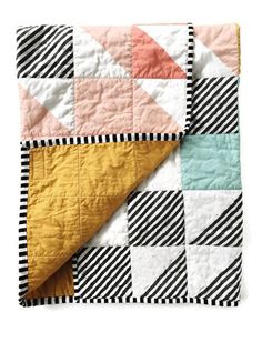 a black and white striped blanket with an orange, yellow, pink, and green patchwork design