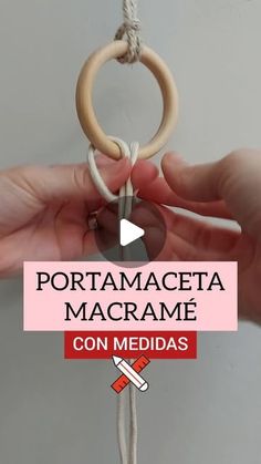 a person holding a wooden ring on top of a white string with the words portamageta macrame con medidas