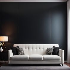 a white couch sitting in front of a black wall