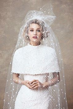 a woman in a white wedding dress and veil