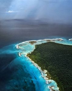 an aerial view of the ocean and landforms in the middle of the ocean with blue water