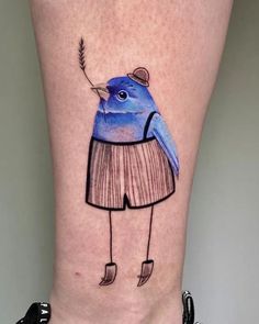 a small blue bird with a hat and sweater on it's leg is shown