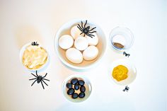 eggs and other ingredients are arranged in bowls on a white surface, including black widowes