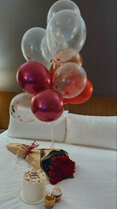 a bunch of balloons that are on top of a bed