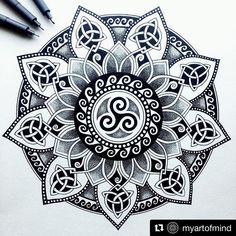 a drawing of a flower with an omen symbol in the center and two pens next to it