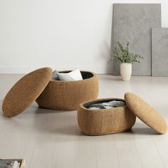 two round stools sitting on top of a hard wood floor next to a potted plant