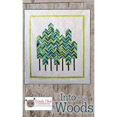 the cover of into the woods quilt pattern, featuring trees in green and blue colors