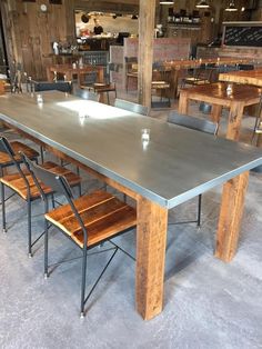 a long table with chairs around it in a room filled with wooden tables and chairs