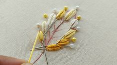 someone is stitching together some yellow and white needles