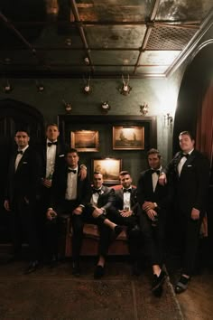 a group of men in tuxedos posing for a photo