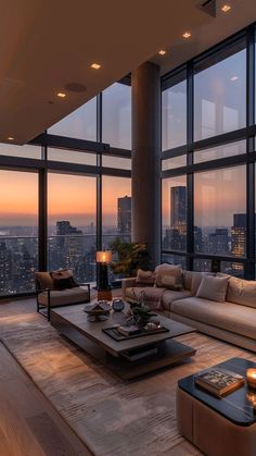 a living room filled with lots of furniture and large windows overlooking the city at sunset