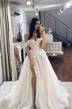 a woman is taking a selfie in her wedding dress while standing on the floor