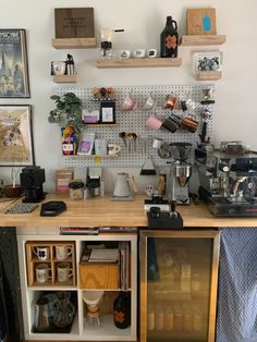 a coffee bar with lots of cups and other items on the wall behind it,