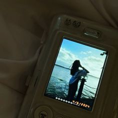 a cell phone with an image of a woman on the screen in front of her