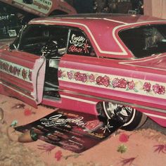 an old pink car with roses painted on it