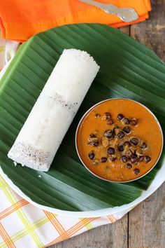 a plate with some food on it and a banana leaf next to the plate is half eaten