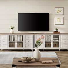 a living room scene with focus on the entertainment center and large screen tv in the background