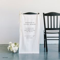 a chair next to a white towel with the words reserved in loving memory on it