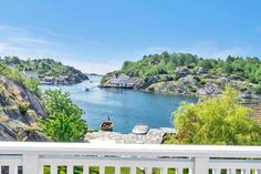 a view of the water from a deck in front of some trees and houses with boats on it