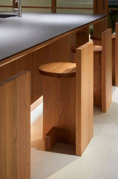 two stools sit in front of a counter with a sink and window behind them