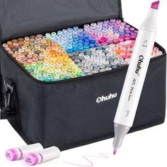 an open case filled with markers and crayons next to a white marker pen