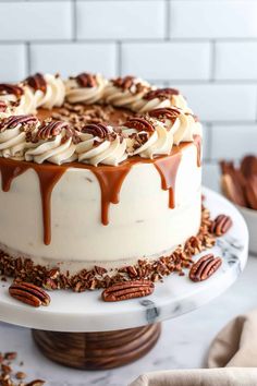 a cake with pecans and caramel drizzled on top is sitting on a plate