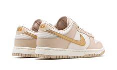 The Women’s Nike Dunk Low “Phantom/Metallic Gold” is a women’s-exclusive colorway of the classic low-top shoe with a premium-looking design.  In the “Phantom/Metallic Gold” rendition, Nike updates the retro basketball shoe with a white leather construction with Phantom-colored leather overlays.  A Metallic Gold leather Swoosh appears on the sides and gold “Nike” branding is embroidered on the heel.  Additional gold accenting includes a “Nike” logo on the tongue.  A Sail midsole and Phantom rubbe Gold Swoosh Dunks Outfit, Womens Dunk Low, Metallic Gold Shoes, Adidas Sl 72, Pop Shoes, Dunks Low, Gold Nike, Nike X Travis Scott, Ugg Ultra Mini