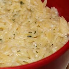 a red bowl filled with rice on top of a table