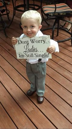 a little boy holding a sign that says don't worry cakes, i'm still single