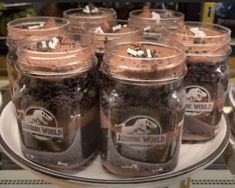 there are many jars filled with chocolate desserts on the tray in front of each other