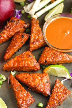 grilled chicken wings with dipping sauce on the side and vegetables around them, ready to be eaten