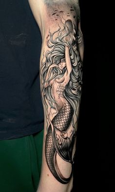 a woman's arm with a tattoo on it and an image of a mermaid