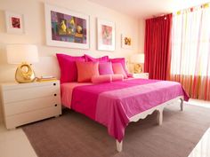 a bed with pink sheets and pillows in a bedroom next to a painting on the wall