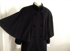 80s does 50's style swing coat black cape coat velvet trim coat by F. BAUER extravagant black coat elegant statement coat winter wool coat, 70% wool, 30% polyester and the lining is acetat. No label size. Double  breasted with velvet covered buttons have a velvet trim on the collar. Padded shoulders.  GOOD VINTAGE CONDITION BUT THE ITEM IS NOT DRY CLEAN.  F. BAUER (FRIDOLIN BAUER) is a german clothing company established in 1947 by founder FRIDOLIN BAUER. IF YOU BUY THIS ITEM, YOU WILL RECEIVE A Fitted Fall Cape For Costume, Fitted Cape For Fall Costume, Winter Costume Cape Outerwear, Fitted Cape For Costume, Winter Season, Fitted Cape For Costume And Winter, Winter Costume Cape, Fitted Cape For Winter Costumes, Fitted Black Wool Coat For Evening, Fitted Cape For Costume Occasions In Winter