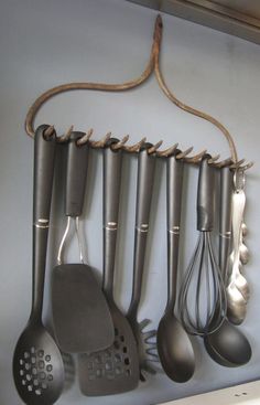 an image of kitchen utensils hanging on the wall with text that reads use an old rake to hold your kitchen utensils via recy art