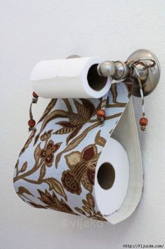 a toilet paper holder with two rolls of toilet paper hanging from it's side