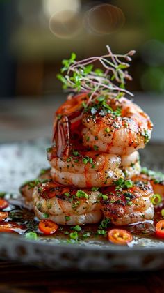 a stack of shrimp on a plate with garnishes and seasoning sprinkles