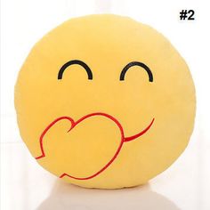 a yellow smiley face pillow sitting on top of a white table