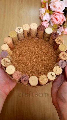 two hands are holding a wine cork coaster