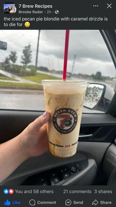 a person holding up a drink in their car