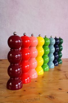 a row of colorful plastic balls sitting on top of a wooden table