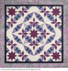 a purple and blue quilt with stars on it's center, in the shape of a star