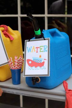 there is a sign that says water on the side of a blue plastic container and some other items