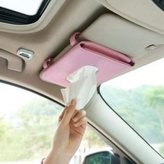 a woman is holding tissue in her car