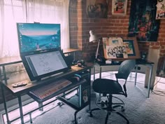 a computer desk with a laptop on top of it next to a chair in front of a window