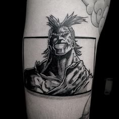 a black and white photo of a man's arm with an anime character on it