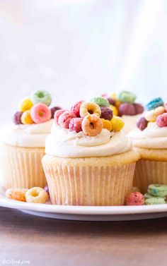 some cupcakes with cereal and milk on top are sitting on a white plate