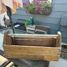 a wooden crate sitting on top of a patio table next to a potted planter