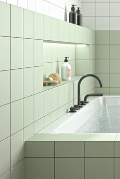 a bath tub sitting next to a white tiled wall